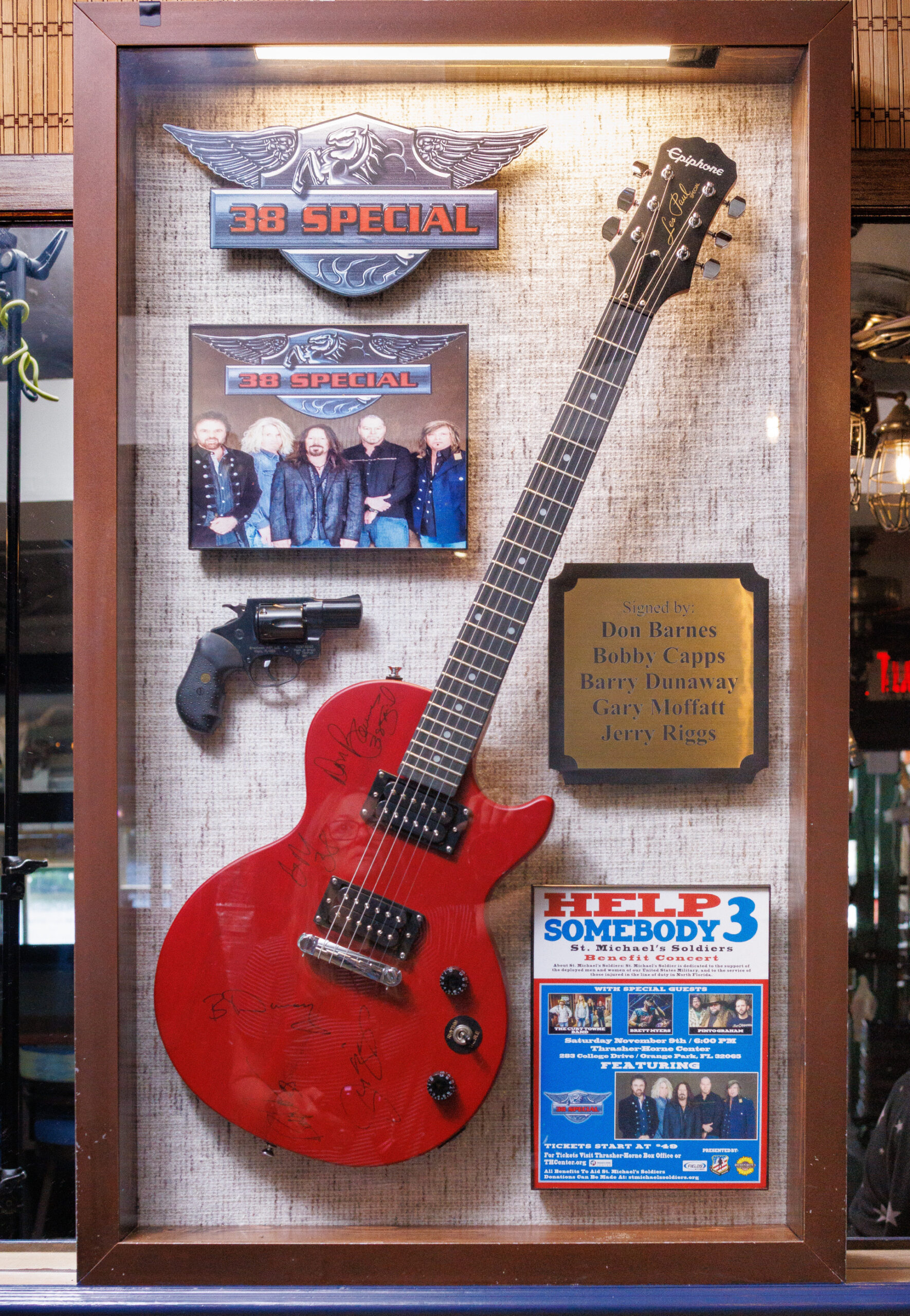Display case featuring a red autographed electric guitar, 38 Special memorabilia, a signed plaque, and concert promotional materials.