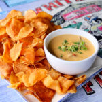 seafood queso dip on a plate with home made chips surrounding it