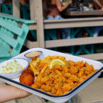 fried crawfish tails on a platter with hush puppies