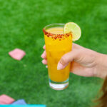 yellow drink with orange salt rim and lime on side