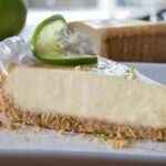 piece of key lime pie on a plate with whipped cream and lime wedge on top