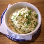 mixture of cole slaw topped with parsley in a bowl