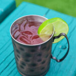 pink drink in a copper mug with a lime wheel