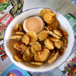pickles fried in a white bowl with a pink sauce